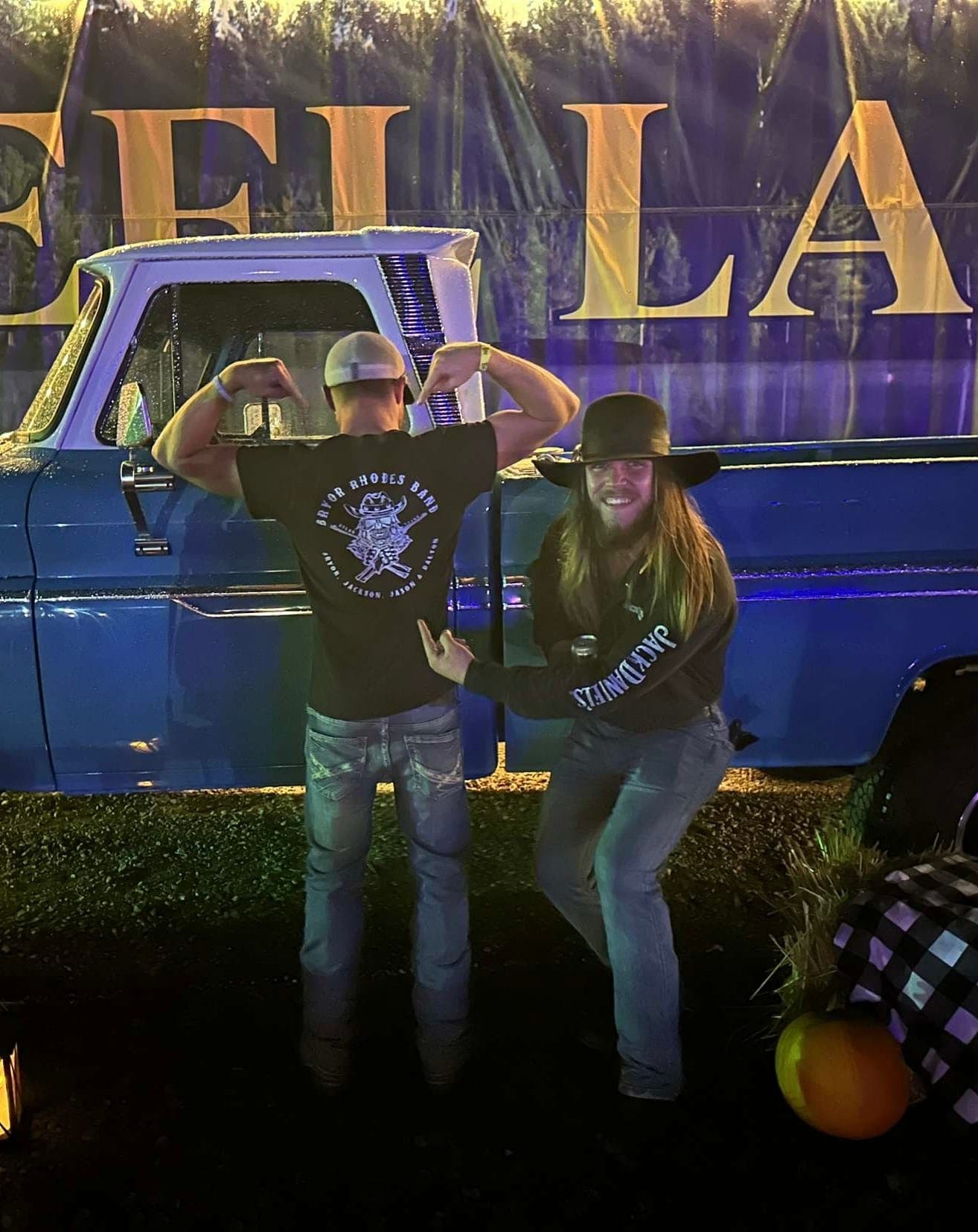 Bryor Rhodes and a bandmate posing by a vintage truck